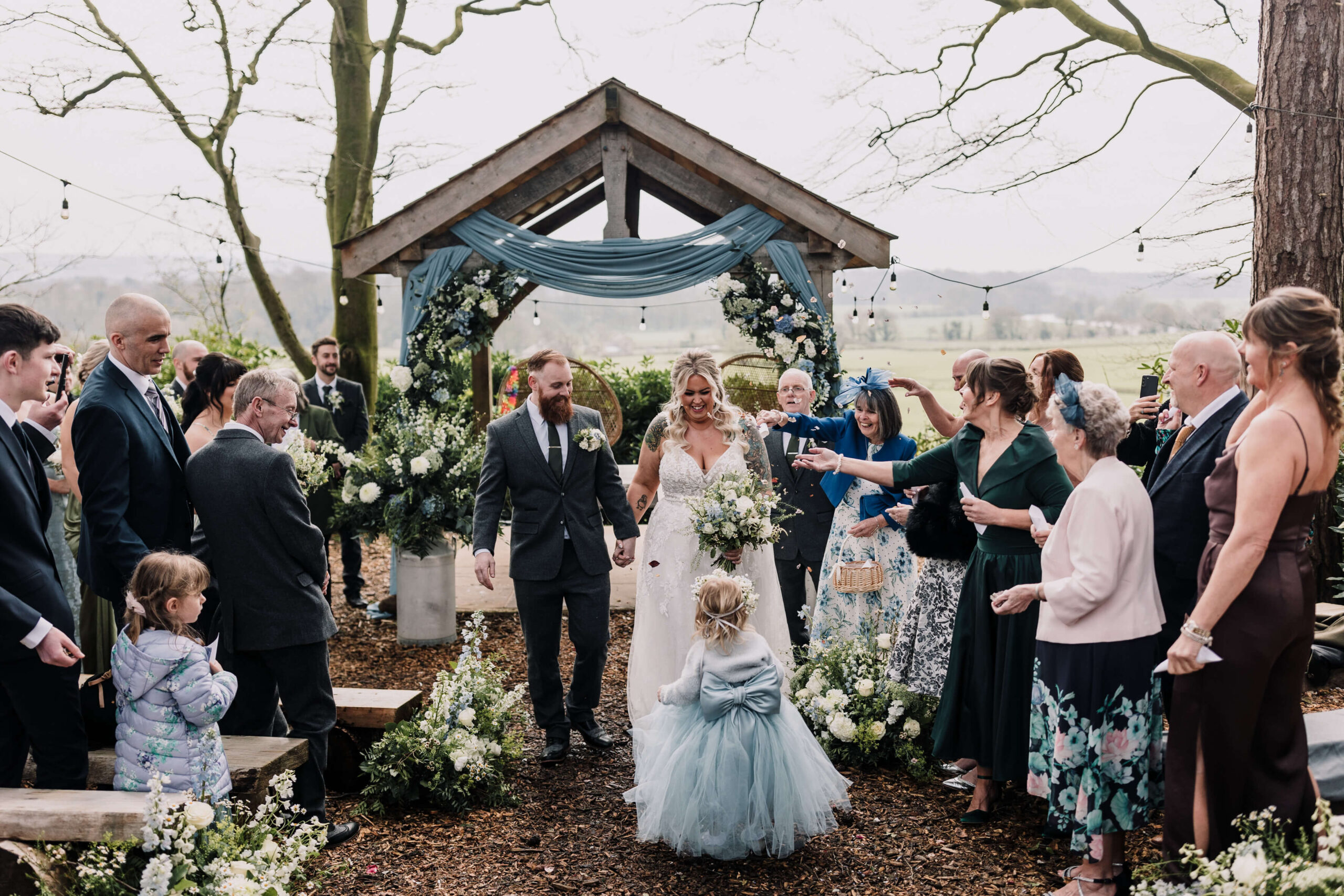 bride and groom walk up the woodland aisle at hobbit hill