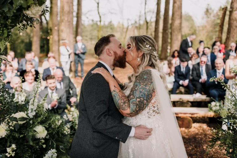 Bride and groom kiss under the canopy of the wood at hobbit hill